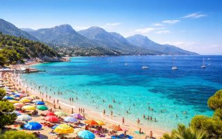 plage-mediterranee-parasols-montagnes-ciel